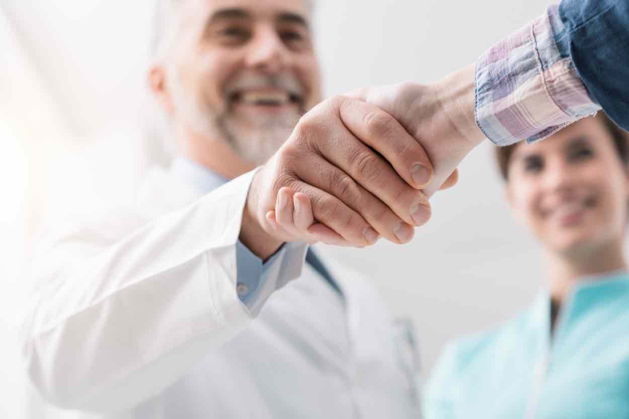 A doctor and patient shaking hands