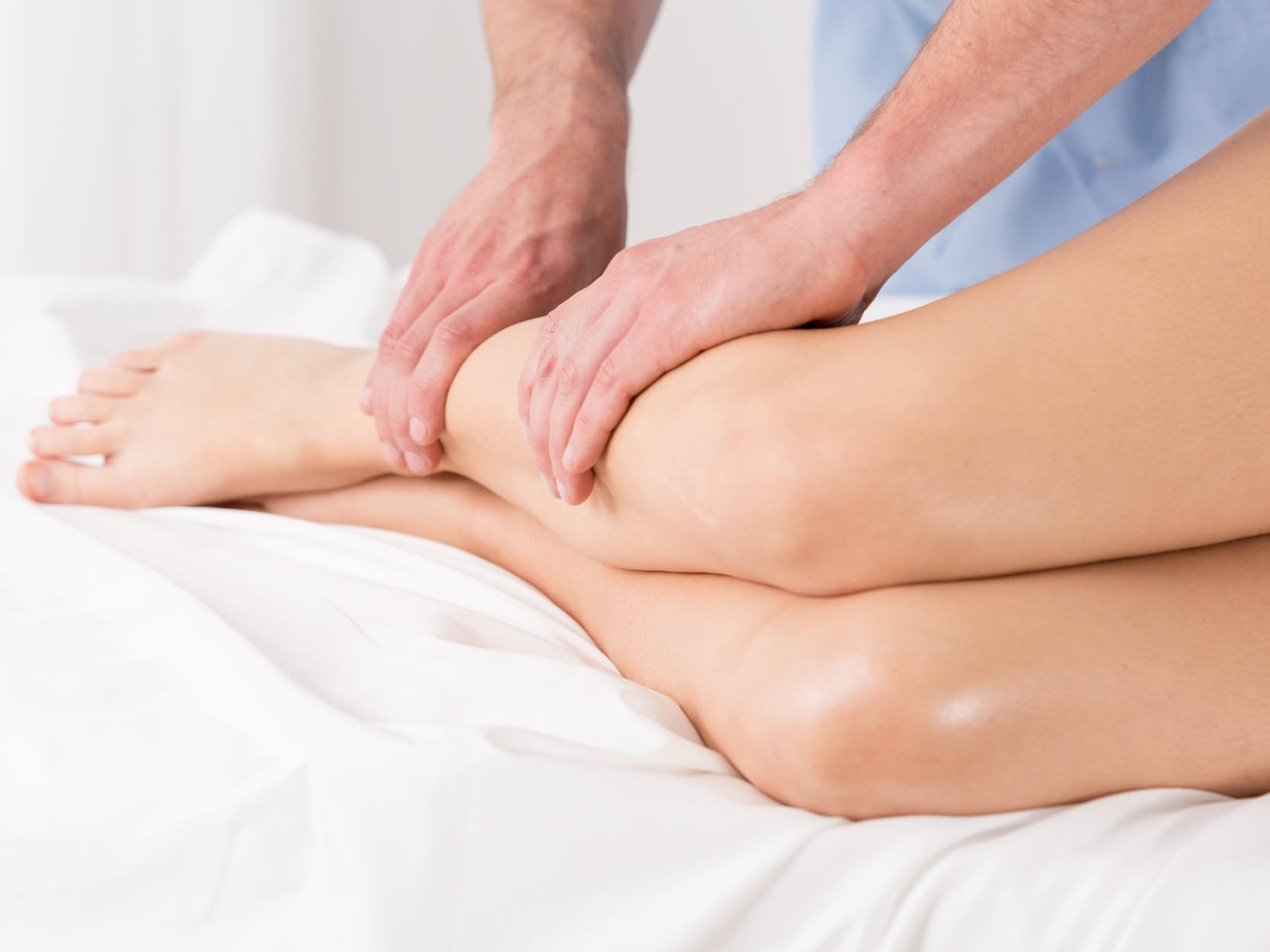 A doctor massaging a patient's legs