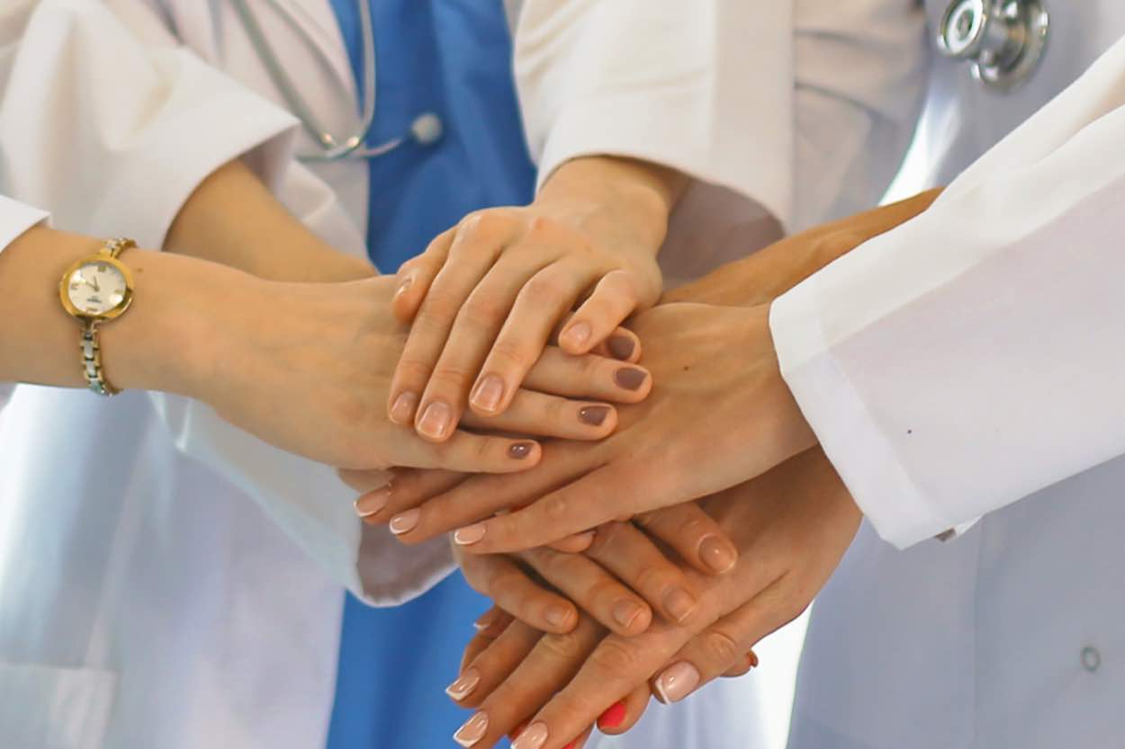 Doctors placing their hands on top of each other